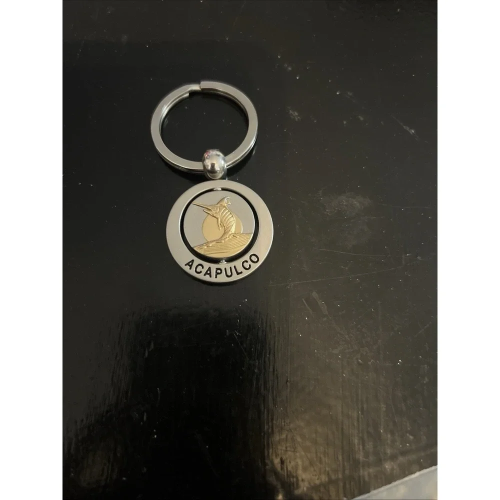 round metal Acapulco souvenir keychain featuring a sailfish design
